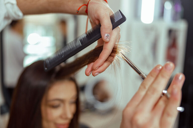 Friseur für feines Haar schneidet Kundin die Haare